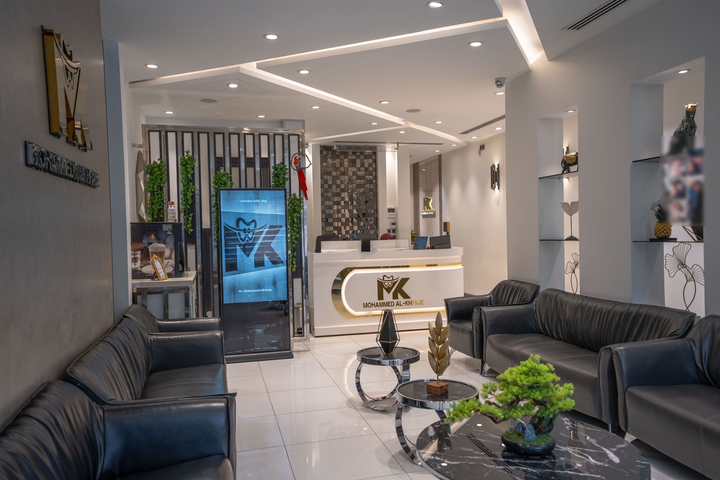 The Mohammed Al-Khfaje Dental Center waiting lounge, with black leather seating leading to the gold-lettered reception desk